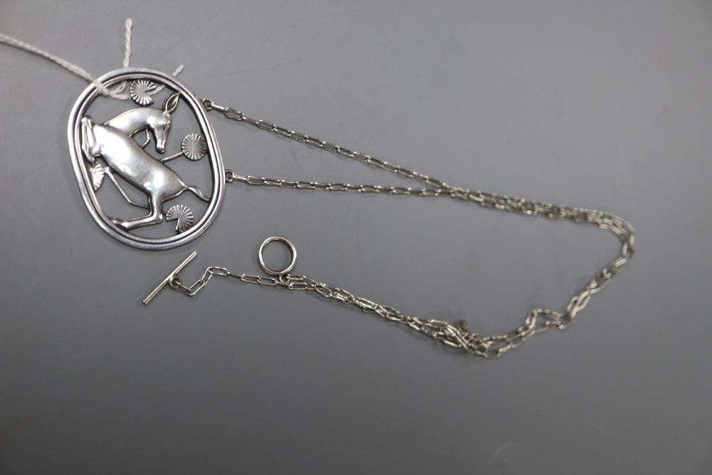 A Georg Jensen sterling kneeling deer oval pendant, no. 95, on white metal chain, 42mm gross 14.8 grams.